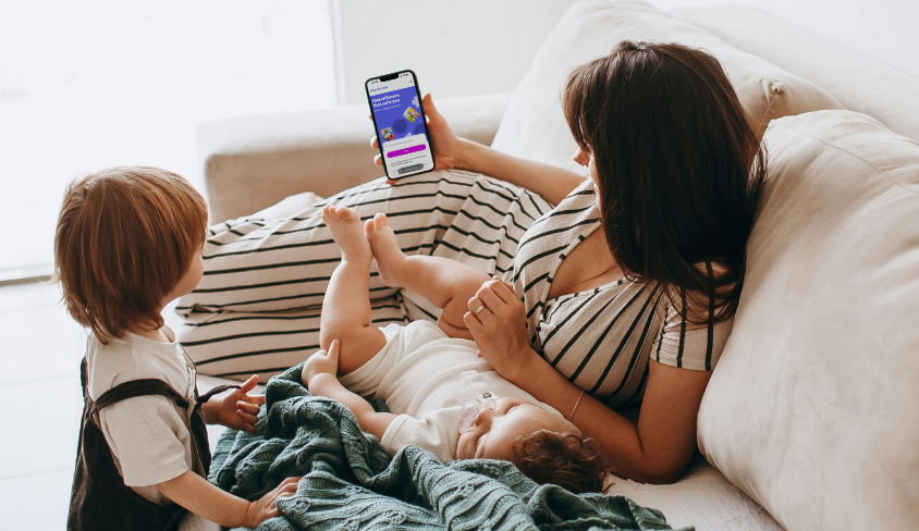 A parent using the Care for Kids app with her children at home